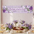 Baby shower banner with floral design and text above a table set with tea cups and sandwiches.