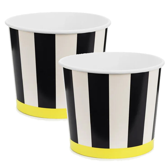 Two paper cups with black and white striped pattern and yellow band on a white background