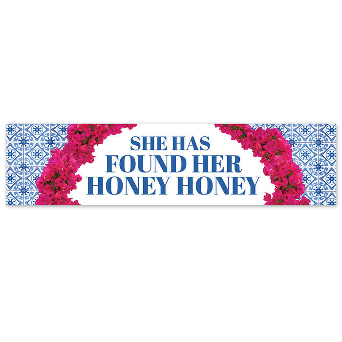 A banner with a blue and white patterned edge and pink floral design, featuring the text 'SHE HAS FOUND HER HONEY HONEY' in bold letters.