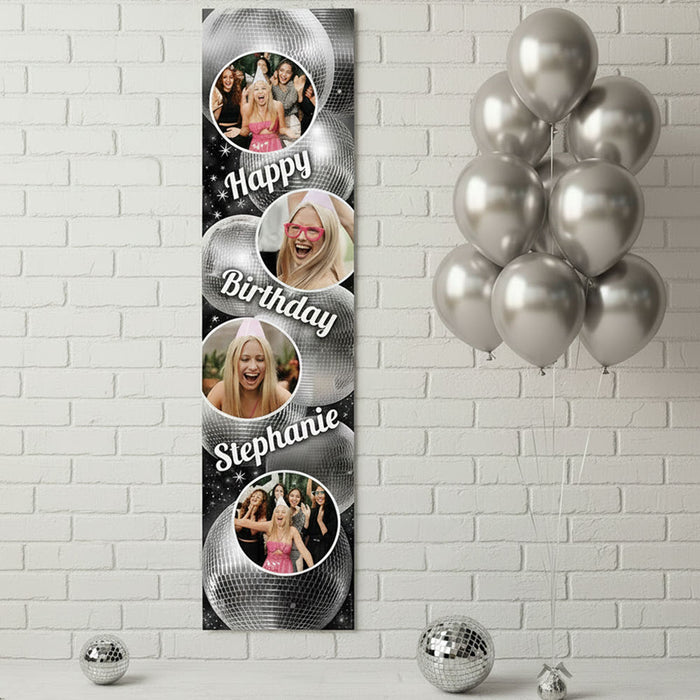Personalized birthday banner with photos and balloons against a white brick wall.