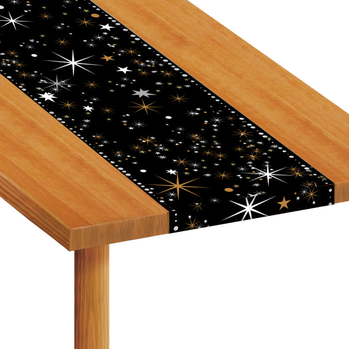 A paper table runner with a New Year's celebratory design, featuring stars and confetti, laid out on a wooden table.