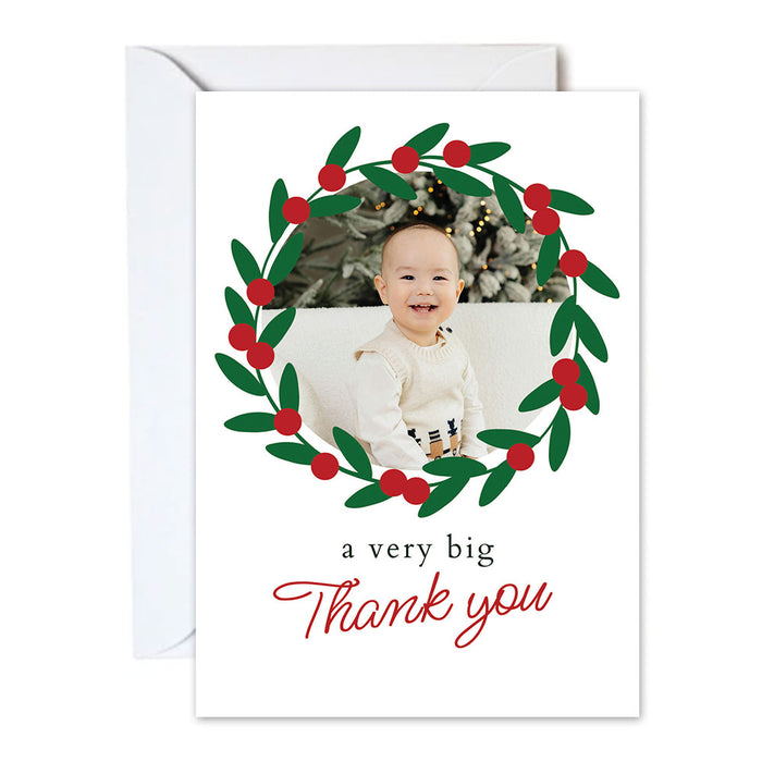 Greeting card with a child's photo surrounded by holly leaves and berries, with 'a very big thank you' text.