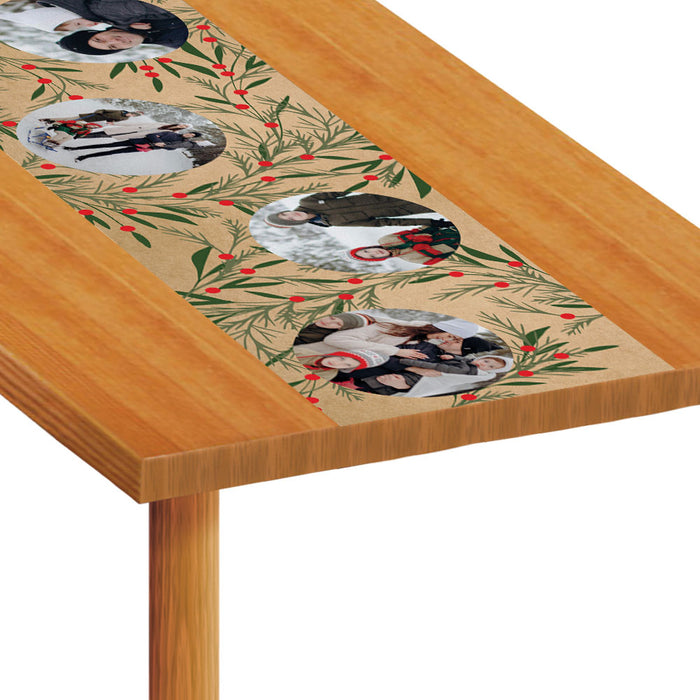 Table runner with festive design featuring penguins and holly on a wooden table.
