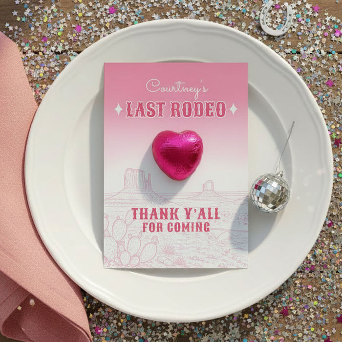 Pink card with 'Courtney's Last Rodeo' text on a white plate with a pink heart and silver ornament, surrounded by glitter.