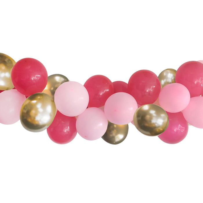 A completed balloon arch garland featuring a mix of gold chrome and pink balloons, including hot pink, light pink, and gold colors.