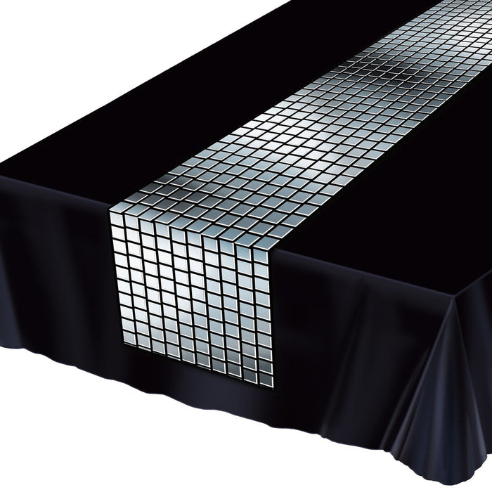 A close-up of a black table runner with a pattern of square disco ball designs in silver.
