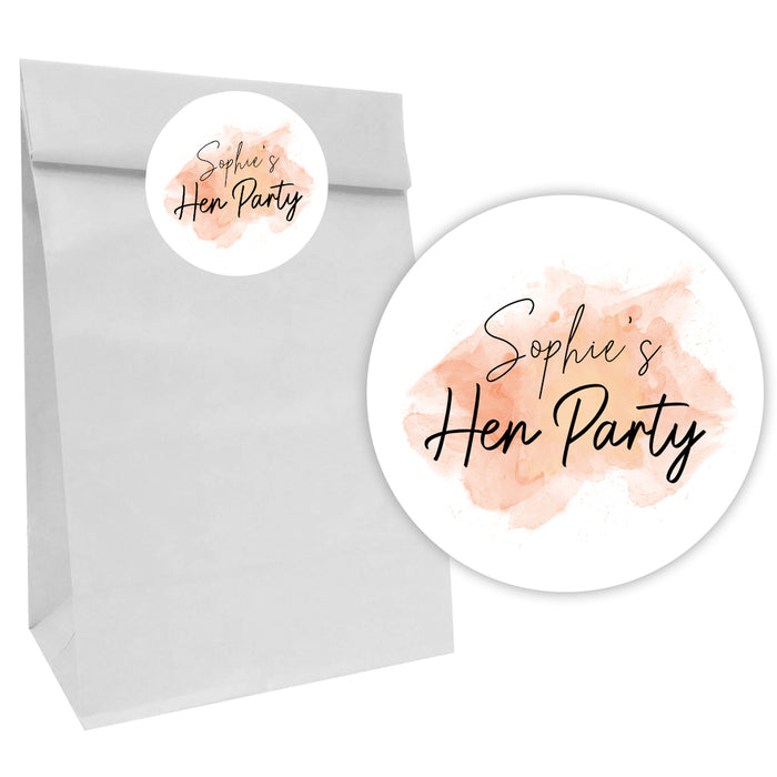 A white party bag with a personalized pink and orange watercolor sticker that reads 'Sophie's Hen Party'.